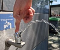 Ein sprudelnder Wasserhahn an einem Metallhaus