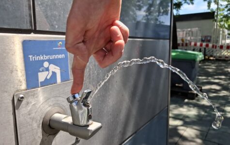 Ein sprudelnder Wasserhahn an einem Metallhaus