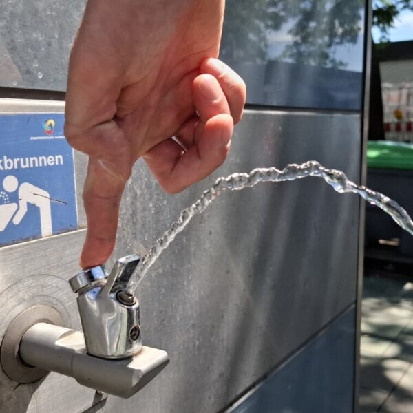 Ein sprudelnder Wasserhahn an einem Metallhaus