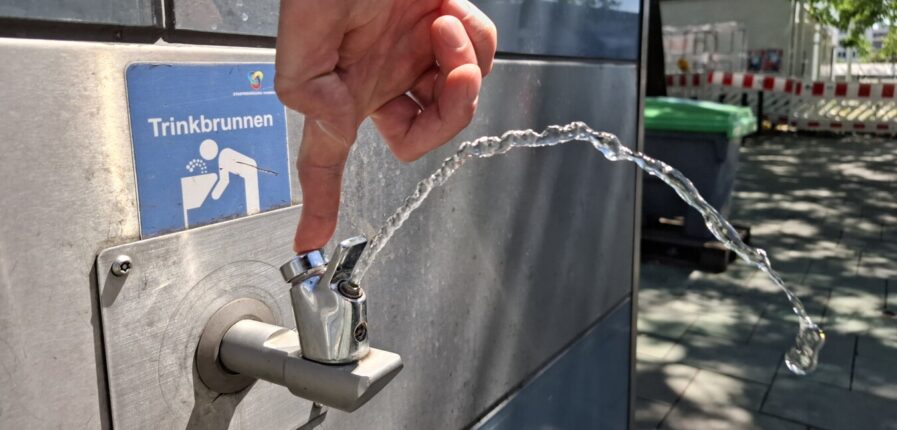 Ein sprudelnder Wasserhahn an einem Metallhaus