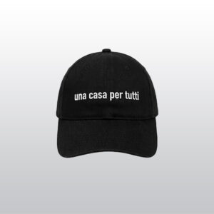Schwarze Schirmmütze mit weißer Stickerei. Text: Una Casa per Tutti". Übersetzt: Ein Haus für alle. An der Seite ist klein der Hinz&Kunzt Schriftzug gestickt.