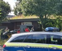 Ein Polizeiauto und mehrere Einsatzkräfte vor der Alimaus
