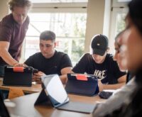 Nah dran: Lehrer Andreas Wichtrup-Ovie hilft den Schülern Valerii Panchuk (Mitte) und Danyil Strupynskyi beim Einrichten der iPads fürs neue Schuljahr. Foto: Imke Lass