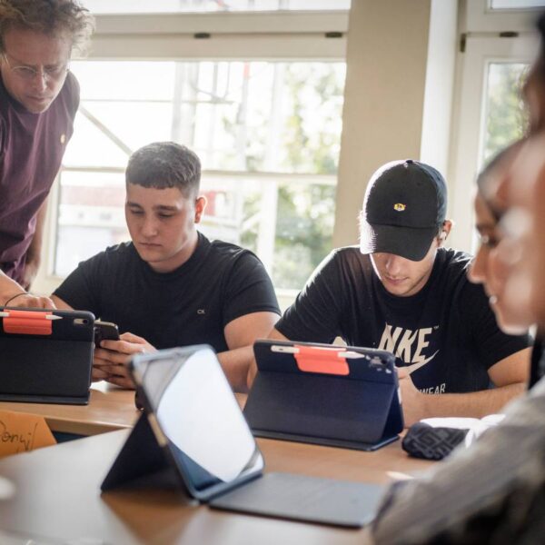 Nah dran: Lehrer Andreas Wichtrup-Ovie hilft den Schülern Valerii Panchuk (Mitte) und Danyil Strupynskyi beim Einrichten der iPads fürs neue Schuljahr. Foto: Imke Lass