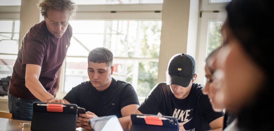 Nah dran: Lehrer Andreas Wichtrup-Ovie hilft den Schülern Valerii Panchuk (Mitte) und Danyil Strupynskyi beim Einrichten der iPads fürs neue Schuljahr. Foto: Imke Lass