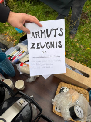 Ein DIN-A4-Papier auf dem mit schwarzem Stift "Armutszeugnis" geschrieben steht.