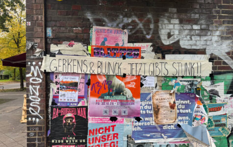 An einer Hauswand hängen viele Plakate. Quer darüber hängt ein Banner mit der Aufschrift: "Gerkens & Blunck – Jetzt gibt's Stunk"