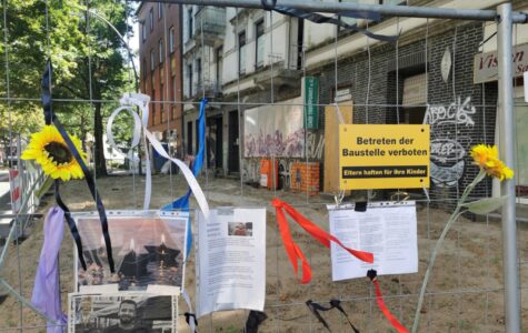 Ein Bauzaun mit angehefteten Fotos von einem Mann, dazu Schriftzüge wie "Rest in Peace Ahmed"